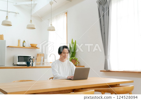 一個人在客廳裡使用個人電腦 一個人在客廳裡使用個人電腦 124528094