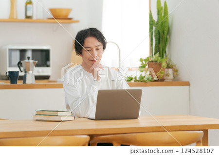 A man who uses a personal computer in the living room A man who uses a personal computer in the living room 124528107