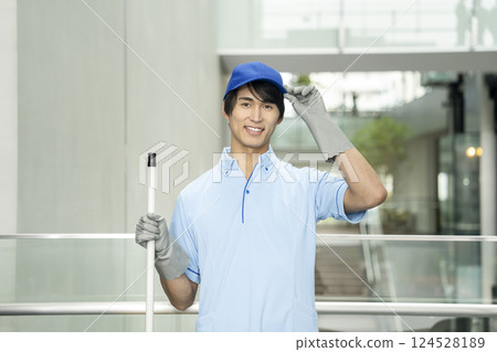 Smiling young male cleaning staff looking at camera Smiling young male cleaning staff looking at camera 124528189