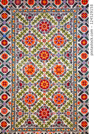 traditional Uzbek geometric pattern on ancient handmade carpet in Uzbekistan. Oriental background with beautiful ornaments traditional Uzbek geometric pattern on ancient handmade carpet in Uzbekistan. Oriental background with beautiful ornaments 124529158