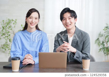 Businessmen and women having a meeting looking at a computer 124529356