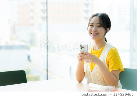A student looking at a smartphone in a cafe 124529463