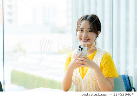 A student looking at a smartphone in a cafe 124529464