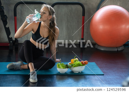 Healthy lifestyle woman drink water at fitness gym.  124529596
