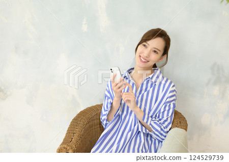 Smiling woman looking at smartphone Smiling woman looking at smartphone 124529739
