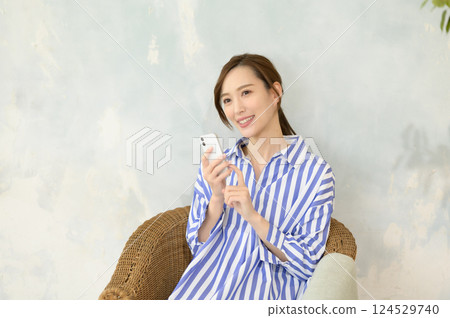 Smiling woman looking at smartphone Smiling woman looking at smartphone 124529740