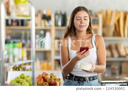 Young woman scanning qr code of cheese Young woman scanning qr code of cheese 124530001