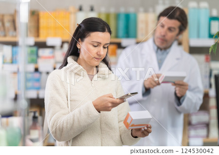 Woman buyer scans pills qr code with man pharmacist 124530042