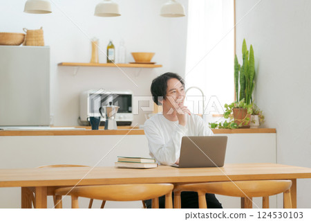 A man who uses a personal computer in the living room A man who uses a personal computer in the living room 124530103