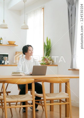 A man who uses a personal computer in the living room 124530104