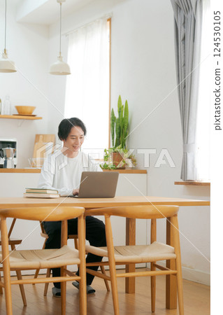 A man who uses a personal computer in the living room A man who uses a personal computer in the living room 124530105