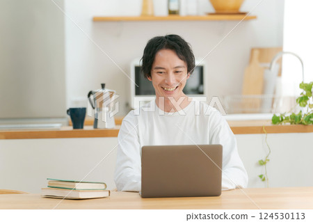A man who uses a personal computer in the living room 124530113