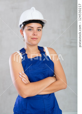Young woman posing in work overalls in studio 124530217