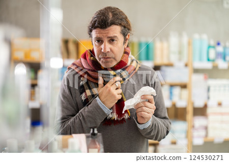 Adult man with sore throat and cough at pharmacy 124530271