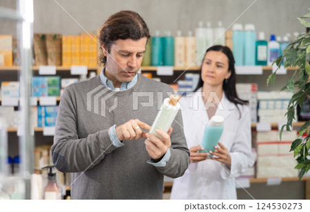 Man chooses shampoo with help of pharmacist Man chooses shampoo with help of pharmacist 124530273