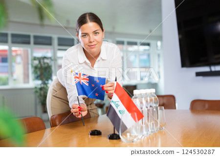 Young lady sets miniatures flags of Iraq and Australia for international negotiations Young lady sets miniatures flags of Iraq and Australia for international negotiations 124530287