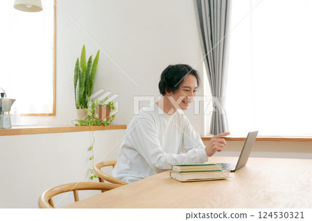 一個人在客廳裡使用個人電腦 一個人在客廳裡使用個人電腦 124530321