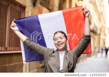 Happy female tourist walking old streets with flag of france Happy female tourist walking old streets with flag of france 124530335