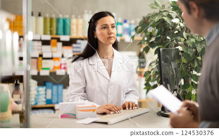 Female pharmacist checking prescription on computer Female pharmacist checking prescription on computer 124530376