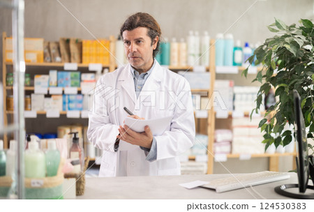 Man pharmacist makes restock, uses paper carrier of information 124530383