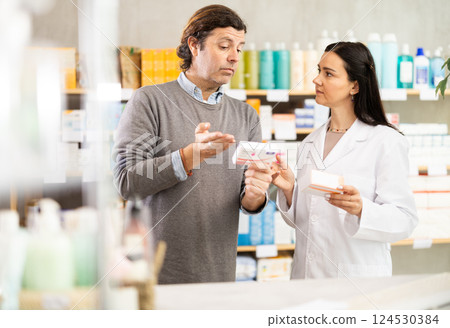 Pharmacist offers paracetamol to man buyer Pharmacist offers paracetamol to man buyer 124530384