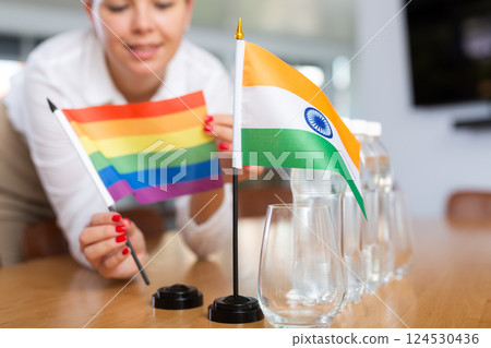 Unrecognizable girl sets midget flags of India and LGBT before international negotiations 124530436