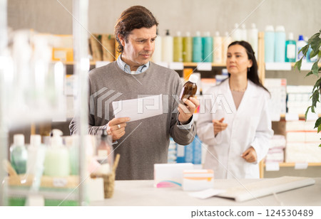 Man buyer scans syrup qr code with woman pharmacist 124530489