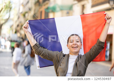 Happy female tourist walking old streets with flag of france 124530497