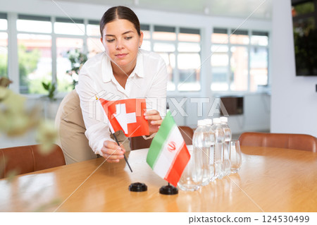 Female secretary places flags of the Iran and Switzerland flag on the table before negotiations of top political figures Female secretary places flags of the Iran and Switzerland flag on the table before negotiations of top political figures 124530499