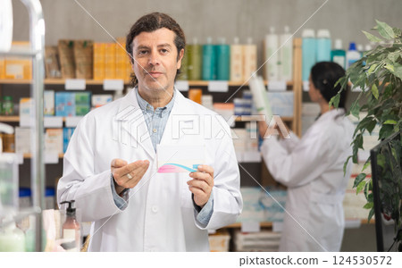 Adult man pharmacist offering pills 124530572