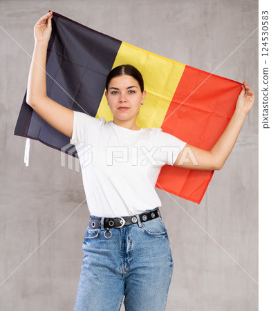 Focused young woman holding Belgium flag Focused young woman holding Belgium flag 124530583