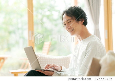 A man who uses a personal computer in the living room 124530726