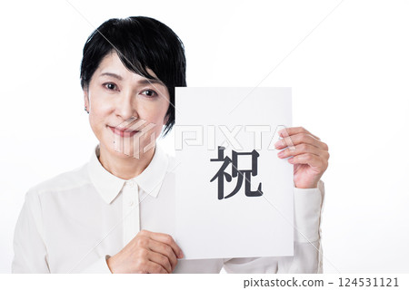 一名黑髮中年婦女微笑著舉著一張紙條，上面寫著“恭喜” 124531121