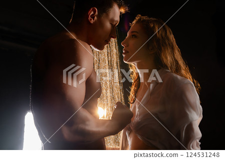 Couple's romantic moment under soft lighting in a dim setting 124531248