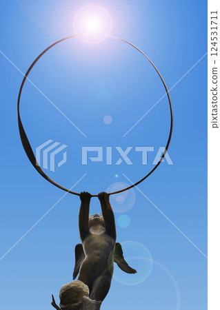 丘比特雕像舉著大圓環指向天空 丘比特雕像舉著大圓環指向天空 124531711