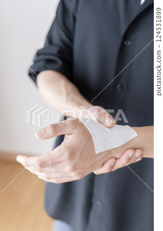 Man applying a compress to his wrist, wrist pain, tendonitis, sprain, joint pain, body parts Man applying a compress to his wrist, wrist pain, tendonitis, sprain, joint pain, body parts 124531899
