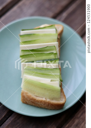 Open sandwich with cucumber and sliced cheese on half a slice of bread Open sandwich with cucumber and sliced cheese on half a slice of bread 124531900