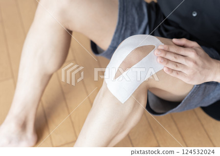 Man applying a compress to his knee, knee pain, sprain, joint pain, body parts 124532024