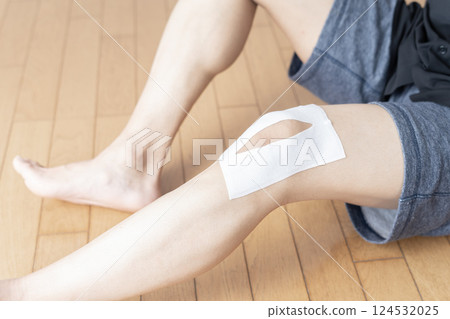 Man applying a compress to his knee, knee pain, sprain, joint pain, body parts 124532025
