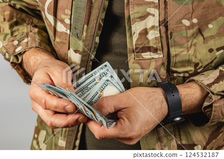 Soldier counting cash in camouflage uniform indoors Soldier counting cash in camouflage uniform indoors 124532187