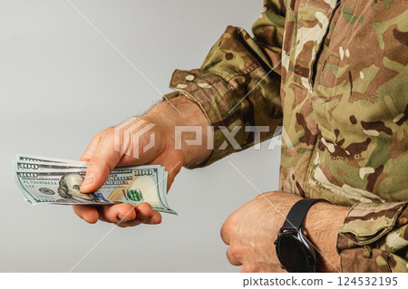 Military personnel handling cash in camouflage attire Military personnel handling cash in camouflage attire 124532195