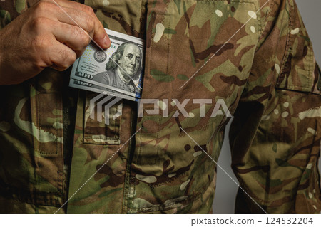 Soldier discreetly placing money in uniform pocket 124532204