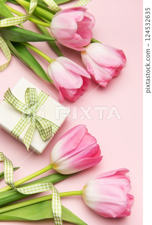 Pink tulips and gift box creating a spring themed flat lay on pink background Pink tulips and gift box creating a spring themed flat lay on pink background 124532635