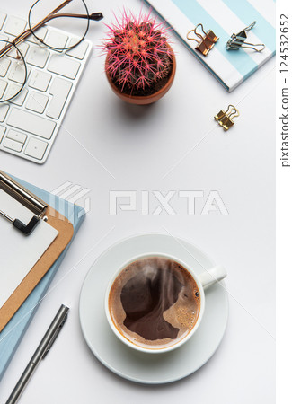 Office worker desk with coffee, keyboard, glasses, plant and notebook on white background 124532652