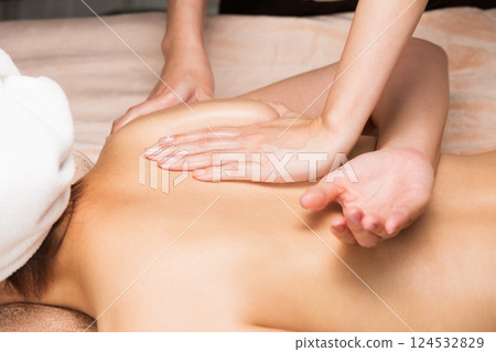 一位年輕的亞洲女性正在接受背部精油按摩。 124532829