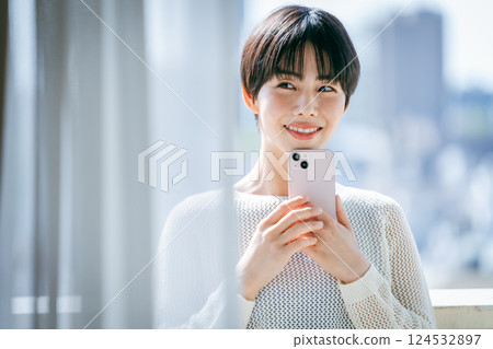 在房間裡操作智能手機的女人 124532897