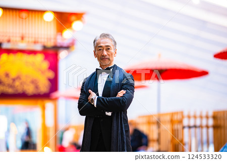 一位身穿燕尾服、張開雙臂、手舉節慶塔的商人 一位身穿燕尾服、張開雙臂、手舉節慶塔的商人 124533320