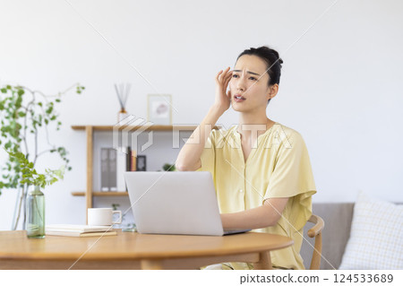 A woman watching a personal computer in the living room A woman watching a personal computer in the living room 124533689