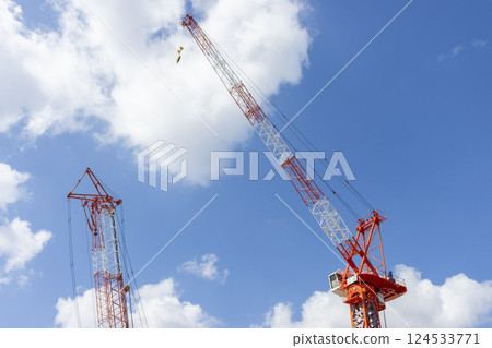 Climbing crane and blue sky. Image of a construction site 124533771