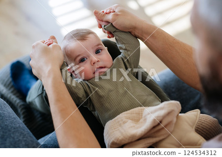 Portrait of baby boy on his father's lap. Portrait of baby boy on his father's lap. 124534312